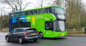 A green electric bus on Magdalen Bridge in Oxford